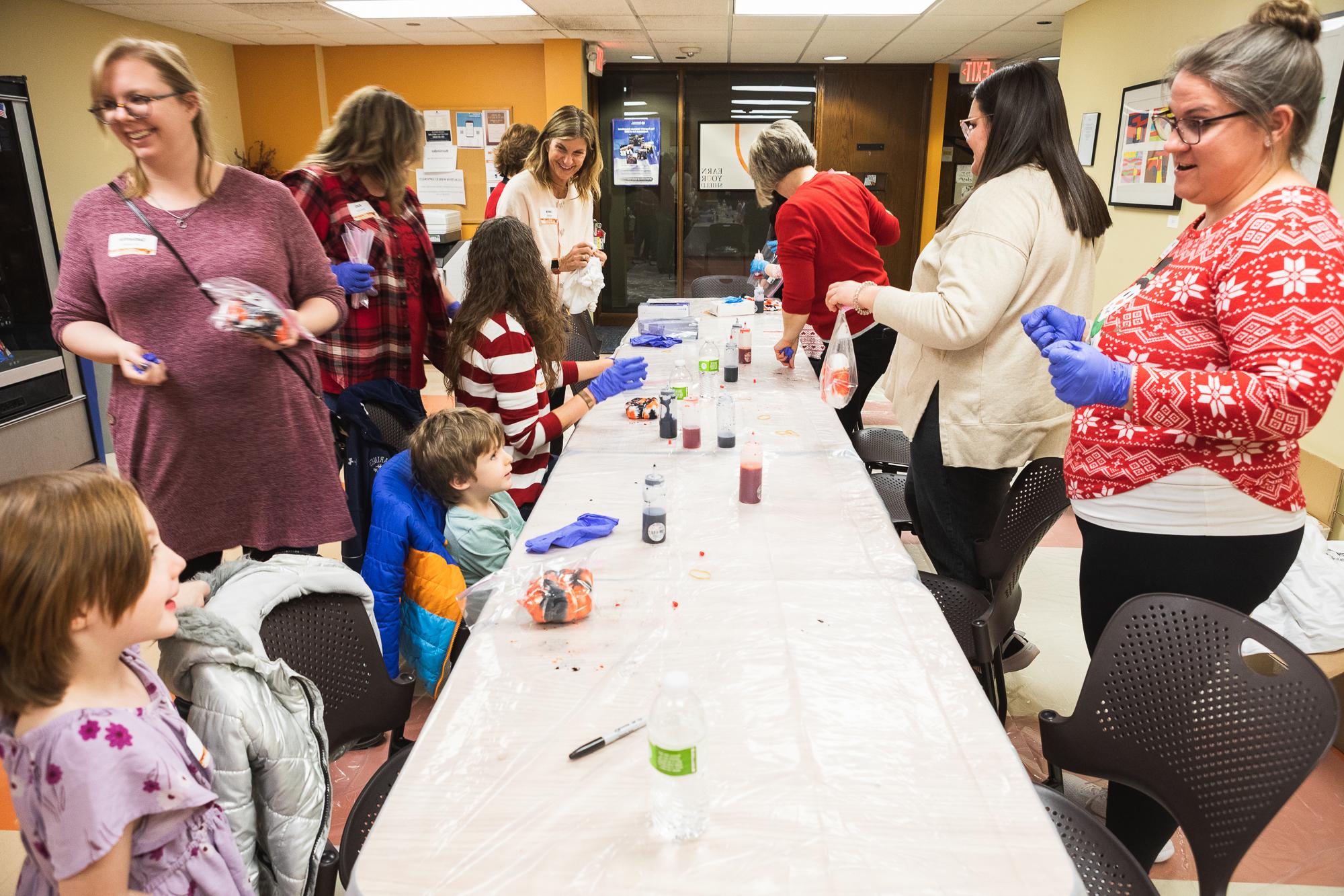 Doane staff and alumni, and their families, make orange and black tie-dye shirts during the Lincoln Holiday Open House on Friday, Dec. 1. 