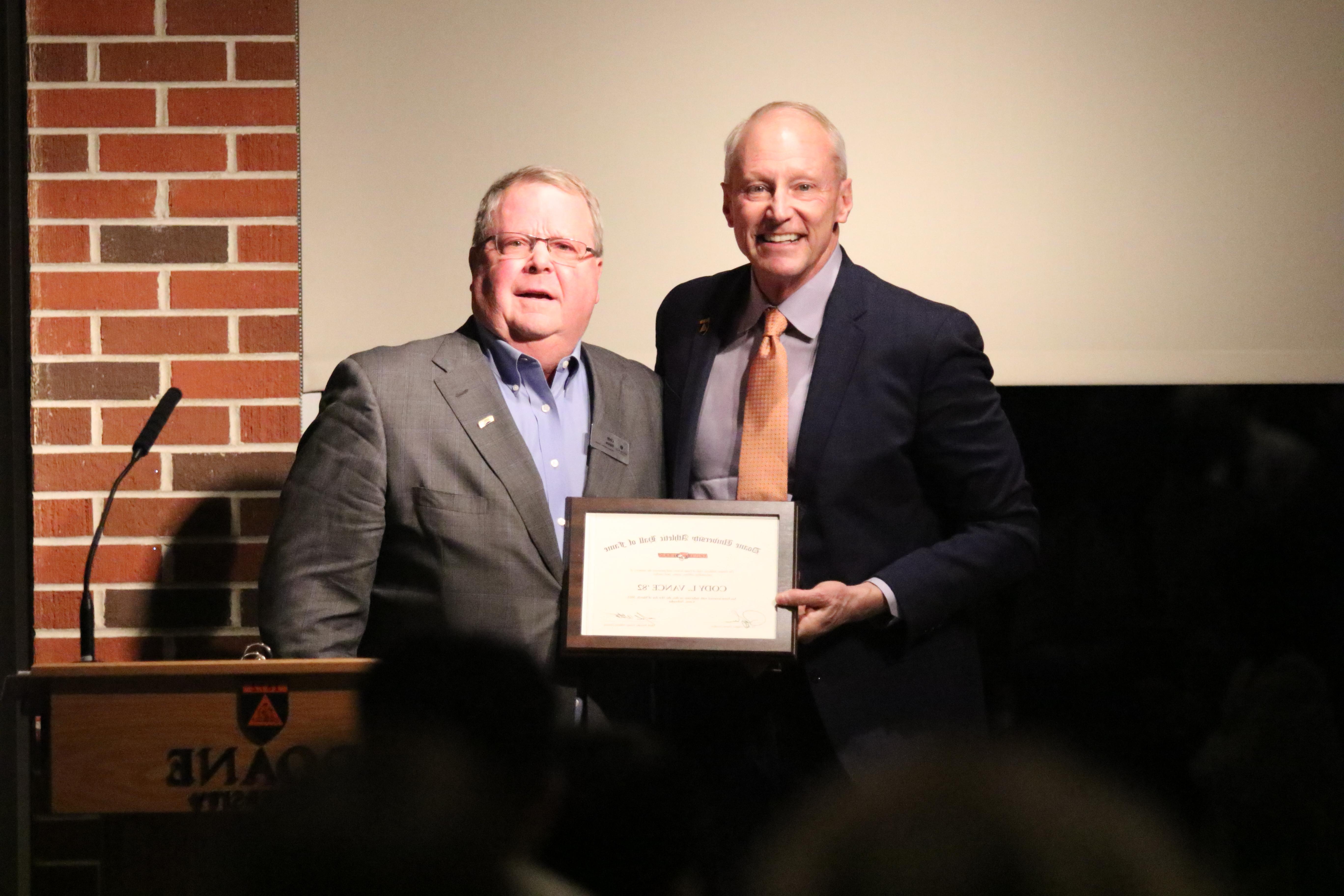 Cody Vance stands next to President Roger Hughes during the Doane Hall of Fame Class of 2023 Ceremony