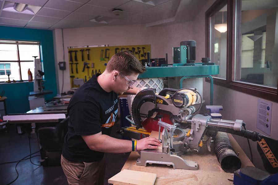 Jeremey Allgeyer, a junior completing his degree in 澳门威尼斯人网址’s Bachelor of Science 工程专业, uses a circular saw to trim a piece of wood in the engineering and physics department’s lab. 