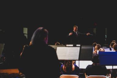 Dr. Andrew Feyes, director of instrumental music at Doane University, directs high school students in the honor band during the Fall Festival of Winds.