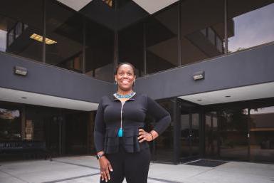 Cat Archie Johnson ’14A stands in front of the Fred D. Brown Center on Doane's Lincoln Campus